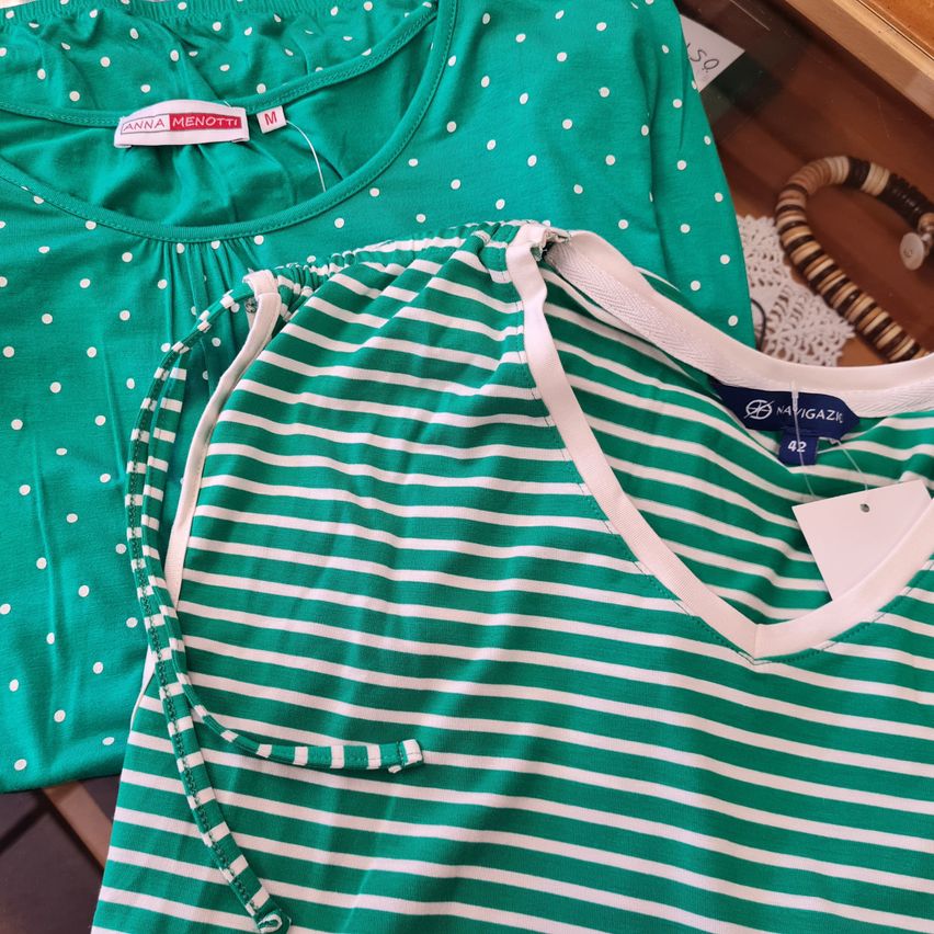 Zwei grüne Schlafanzüge von Anna Menotti. Einer ist gepunktet und der andere gestreift. Beide haben eine Schnürung an der Taille.