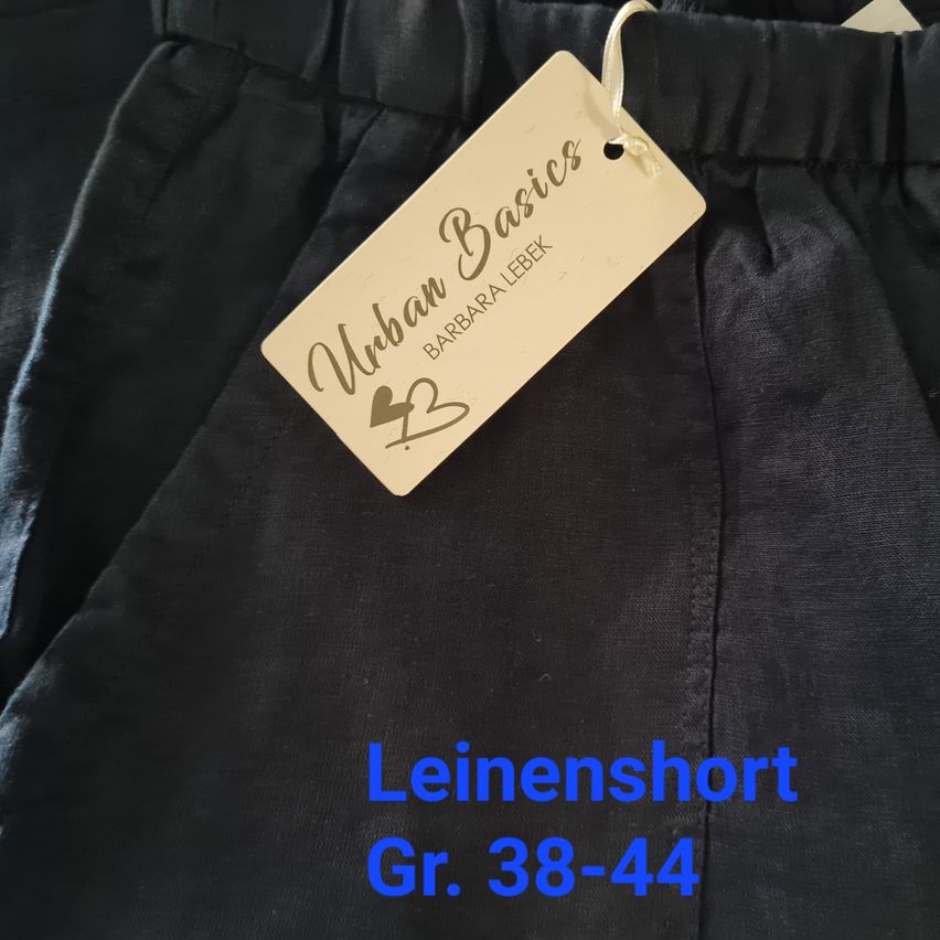 Ein schwarzes Leinenshorts-Etikett sagt Urban Basics, entworfen von Barbara Lebek, und Größe 38-44.