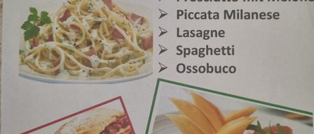 Das italienische Abendmenü umfasst Prosciutto mit Melone, Piccata Milanese, Lasagne, Spaghetti und Ossobuco. Links ist ein Gericht mit Lasagne abgebildet, rechts eine Platte mit Ossobuco.