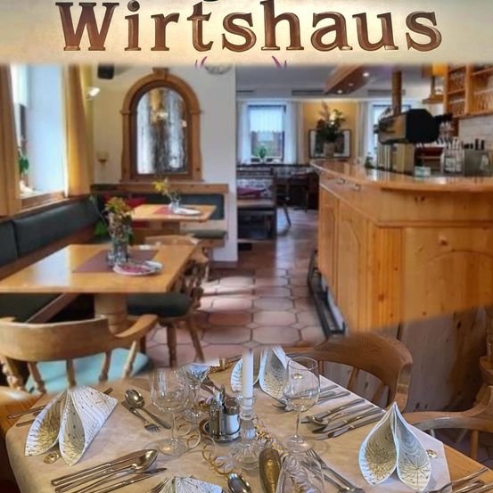 Ein Restaurant-Interieur mit Holztischen und -stühlen, einer Theke und einem großen Spiegel. Das Wort 'Wirtshaus' ist prominent oben angebracht.