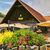 Gartensaison in Österreich: Blumenpracht und Sonnenschirme vor einem Haus
