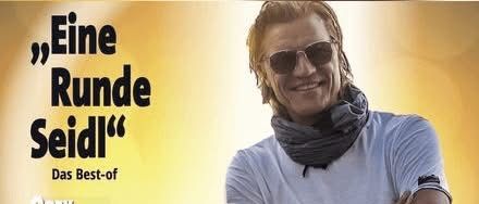 Ein Mann in Sonnenbrille und weißem T-Shirt steht mit verschränkten Armen vor gelbem Hintergrund. Der Text lautet 'Eine Runde Seidl' und darunter 'Das Best-of-Gerry Seidl Kabarett'.