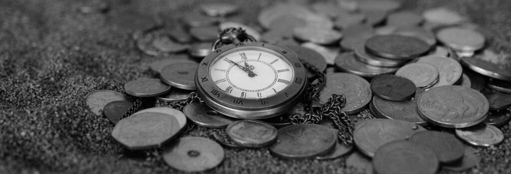 Eine Taschenuhr mit römischen Zahlen liegt auf einem Haufen Münzen und symbolisiert den Wert von Zeit und Geld.