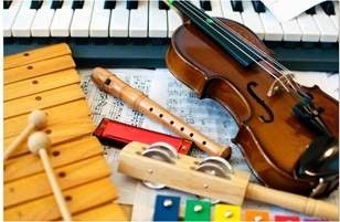 Eine Geige, eine Flöte, ein Mundharmonika, ein Xylophon und eine Reihe von Maracas liegen auf einer Klaviertastatur.