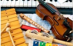 Eine Geige, eine Flöte, ein Mundharmonika, ein Xylophon und eine Reihe von Maracas liegen auf einer Klaviertastatur.