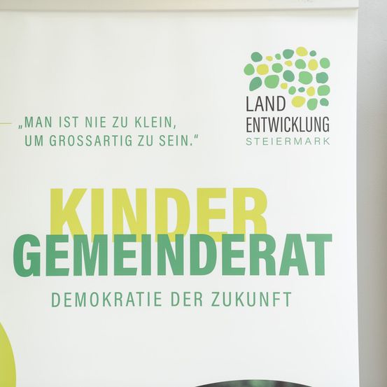Ein Plakat, das einen Kindergemeinderat fördert, mit dem Titel 'Kinder Gemeinderat' und betont die Idee der Demokratie für die Zukunft. Das Plakat enthält einen Zitat in deutscher Sprache.