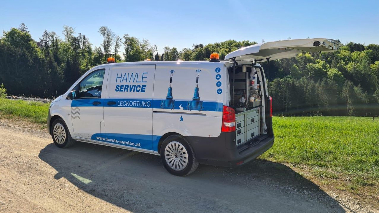 Seitenaufnahme eines Service-Autos mit offener Heckklappe am Straßenrand
