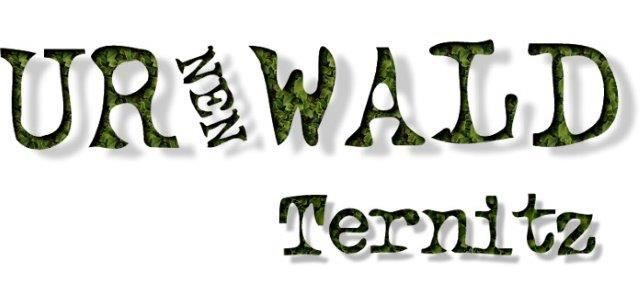 Das Bild zeigt einen stilisierten Text 'Ur Neuen Wald Ternitz' mit 'Ur' und 'Wald' in einer Blattschrift und 'Neuen' und 'Ternitz' in einer Standardschrift. Der Text ist grün.