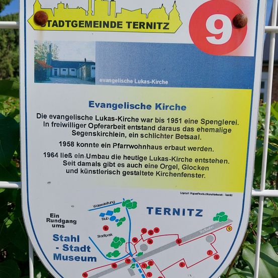 Ein Schild für die Evangelische Lukas-Kirche in Ternitz. Bis 1951 war es eine Fassbinderei. 1958 wurde eine Kirche gebaut und seit 1964 ist es die heutige Lukas-Kirche mit Orgel, Glocken und künstlerisch gestalteten Kirchenfenstern.