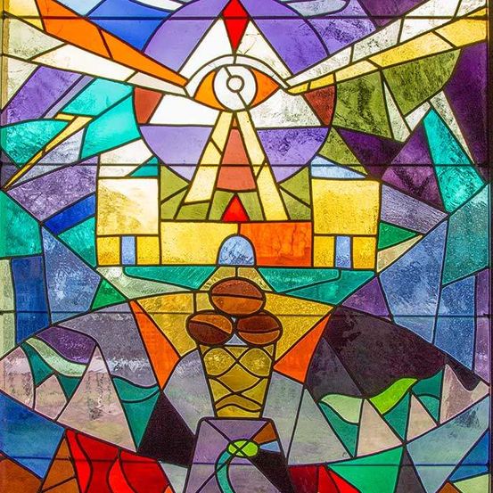 Ein farbenfrohes Bleiglasfenster mit einem zentralen Auge, umgeben von geometrischen Formen in verschiedenen Farben, mit einer kegelförmigen Struktur im Vordergrund.