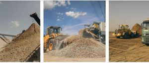 Ein gelber Bulldozer schiebt einen Haufen Steine, während eine graue Maschine Kies abludet.