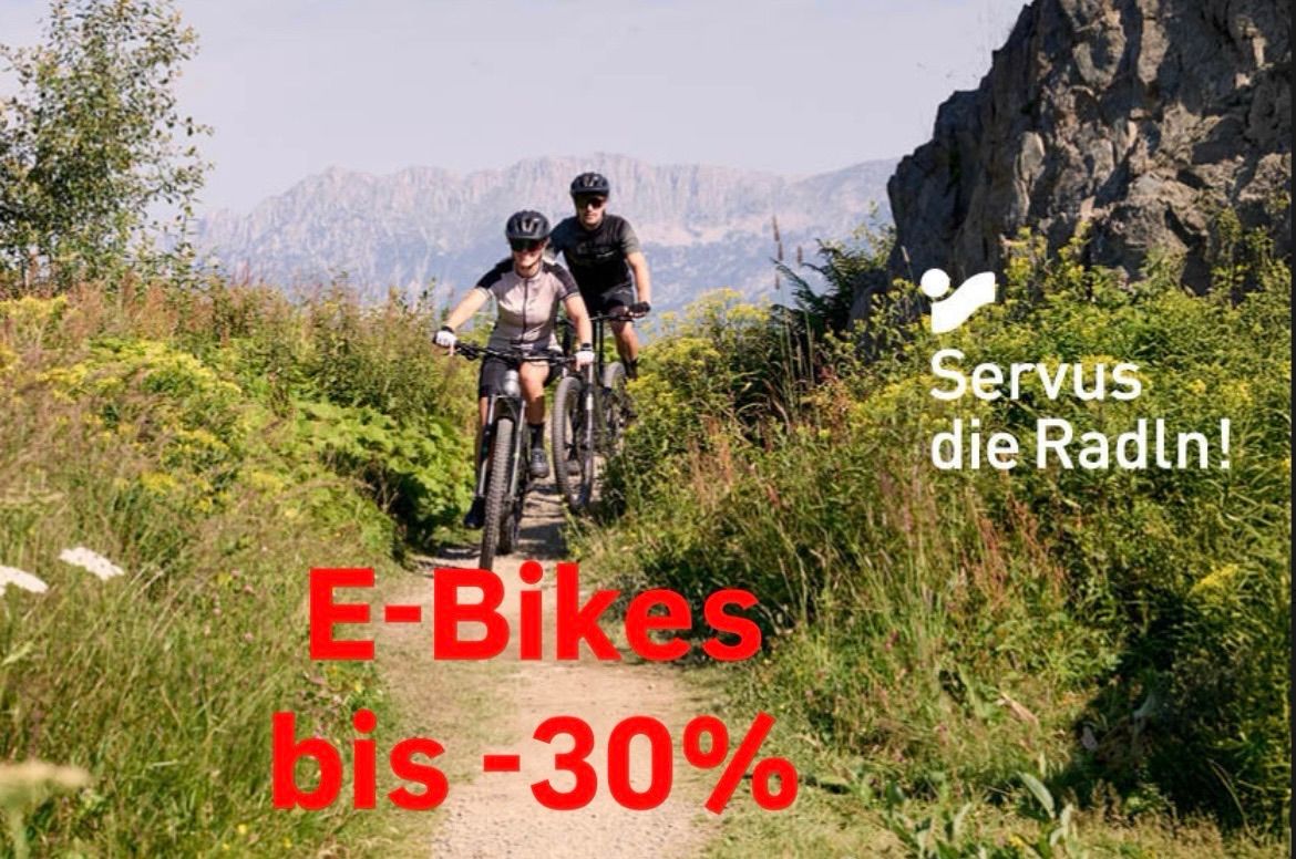 Zwei Personen fahren Elektrofahrräder auf einem Bergpfad mit einer 30% Rabattwerbung.