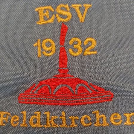 Gesticktes Logo auf grauem Hintergrund mit einer roten Glocke und dem Text ESV 1932 Feldkirchen
