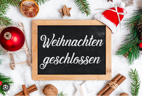 Ein Tafel mit den Worten 'Weihnachten geschlossen' darauf steht zwischen Weihnachtsdekorationen.