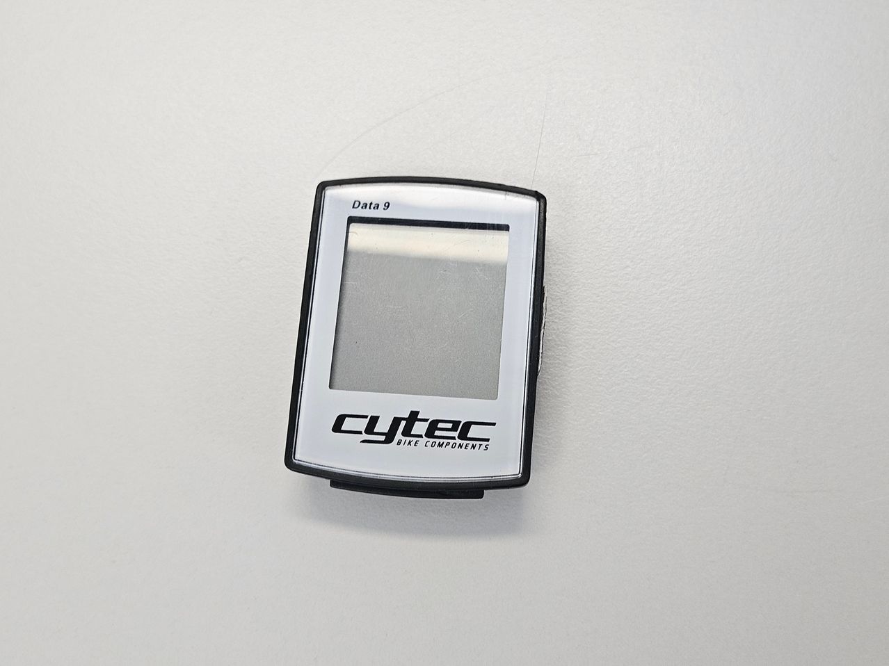 A Cytec Data 9 bike computer is displayed against a white background. The device has a reflective surface and a small screen with text.