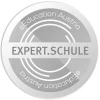 Silbernes kreisförmiges Logo mit 'EXPERT.SCHULE' in fetter, weißer Schrift, umgeben von 'eEducation Austria' in Grau, auf schwarzem Hintergrund.
