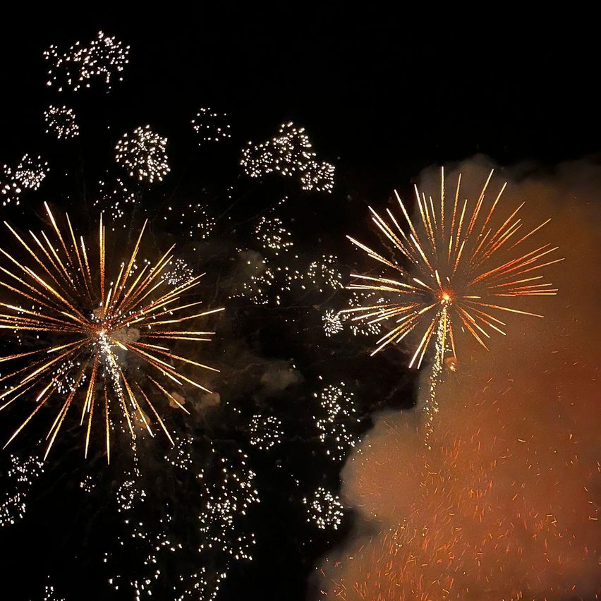 Zwei Feuerwerke explodieren in der Nacht und erhellen den dunklen Himmel mit leuchtenden Farben und Lichtern.