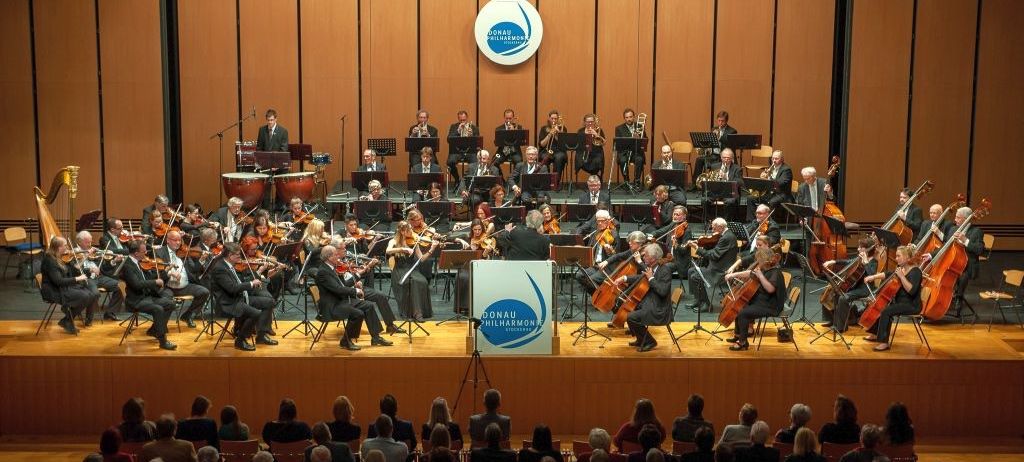 Bild enthält, Indoors, Group Performance, Person, Music, Musical Instrument, Musician, Orchestra, Performer, Room, Music Band