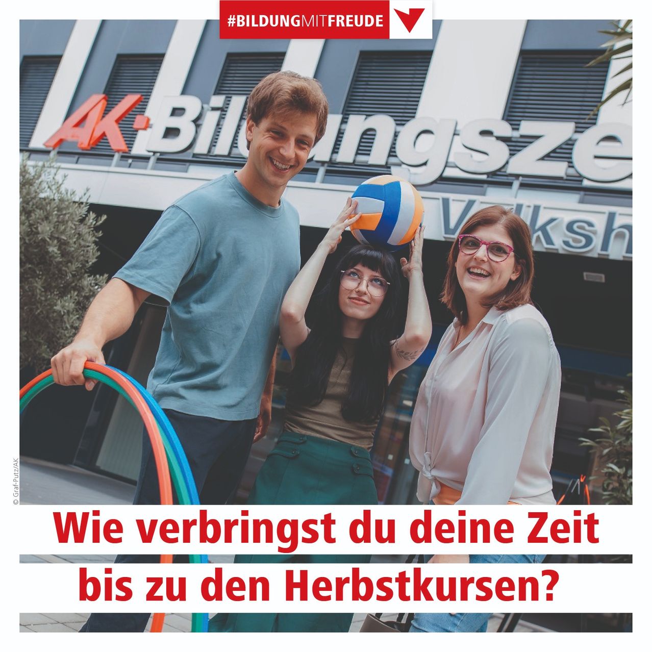 Drei Personen stehen vor einem AK Bildungszentrum-Gebäude, halten eine Volleyball und Hula-Hoops. Das Bild hat eine deutsche Bildunterschrift: 'Wie verbringst du deine Zeit bis zu den Herbstkursen?'.