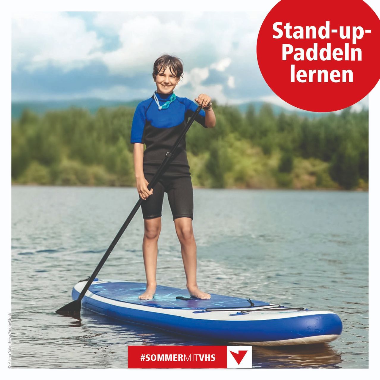 Ein junger Mensch steht lächelnd auf einem Paddleboard mit einem Paddel in der Hand. Das Wasser ist ruhig, und der Hintergrund zeigt Bäume und Berge. Ein roter Kreis sagt 'Stand-up-Paddeln lernen'. Unten befindet sich ein Hashtag '#SOMMERMitVHS'.