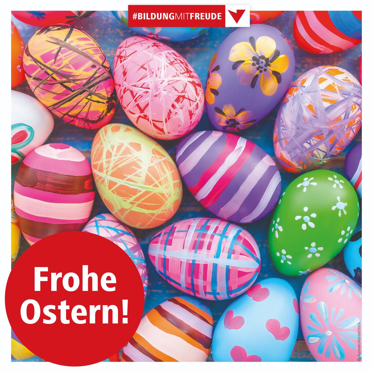 Eine bunte Sammlung von Ostereiern, verziert mit verschiedenen Mustern und Blumen. Die Eier liegen auf einer blauen Oberfläche, mit einem roten Kreis in der Mitte, der 'Frohe Ostern!' sagt.