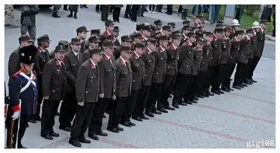 Eine Gruppe von Militärangehörigen in Uniform steht in einer Reihe, wahrscheinlich für eine Zeremonie. Sie tragen Hüte und Schuhe.
