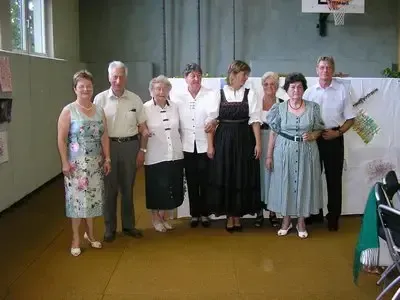Eine Gruppe von sieben Menschen, sowohl Männer als auch Frauen, stehen zusammen in einem Raum und posieren möglicherweise für ein Foto.