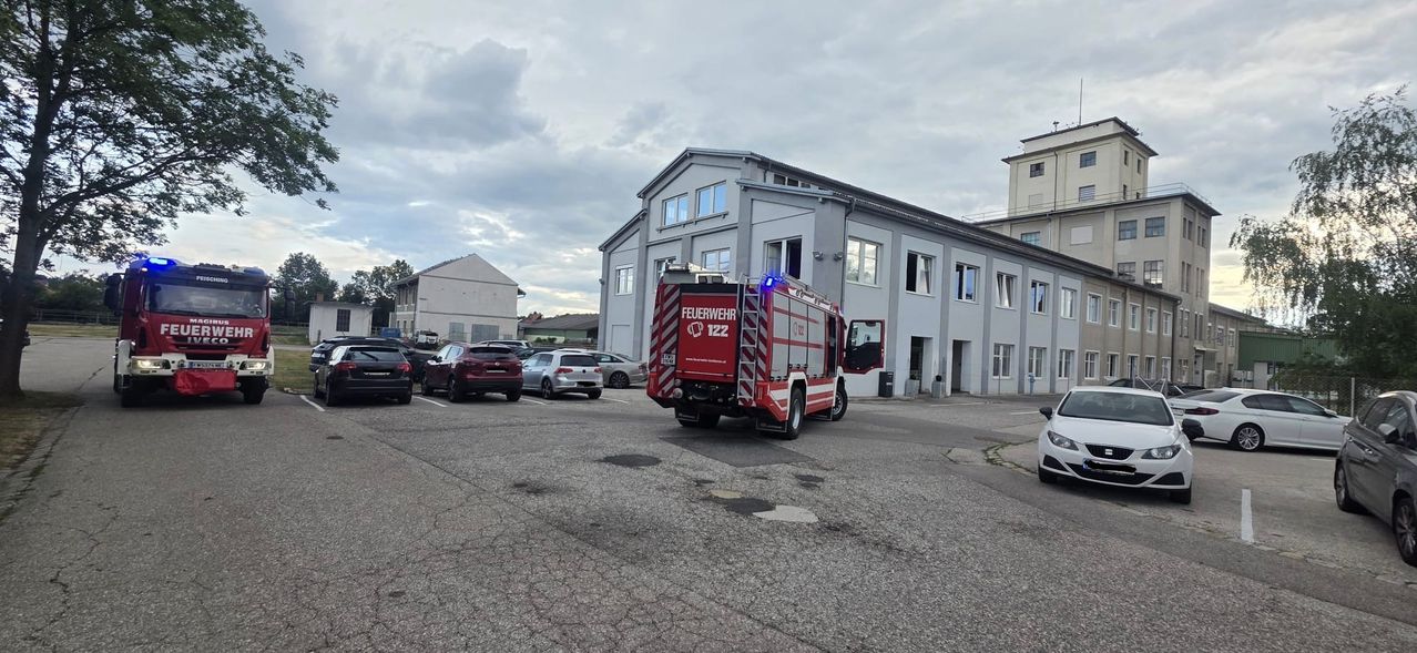 Ein Feuerwehrauto mit der Nummer 122 steht vor einem Gebäude mit mehreren Autos.