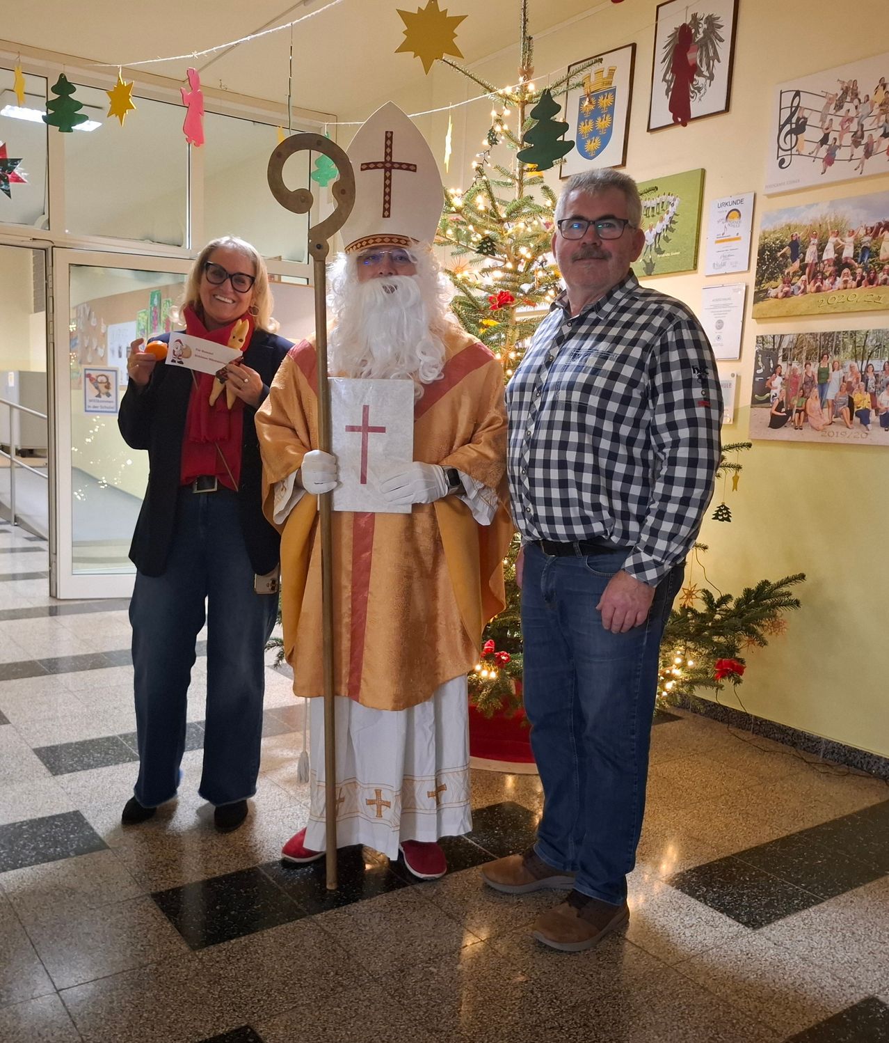 Eine Frau und ein Mann als Heiliger stehen neben einem Weihnachtsbaum mit einem Mann in einem karierten Hemd.