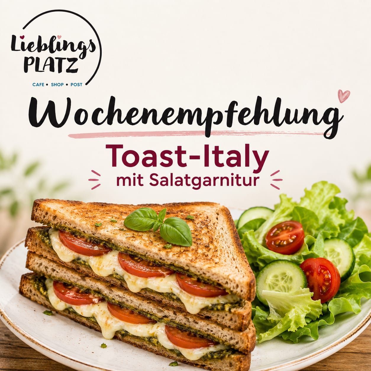 Ein Teller mit Toast-Italy-Sandwich mit Tomaten, Basilikum und Käse, begleitet von einem Salat mit Tomaten und Gurken. Das Bild stammt von Lieblings PLATZ Cafe, Shop, Post.