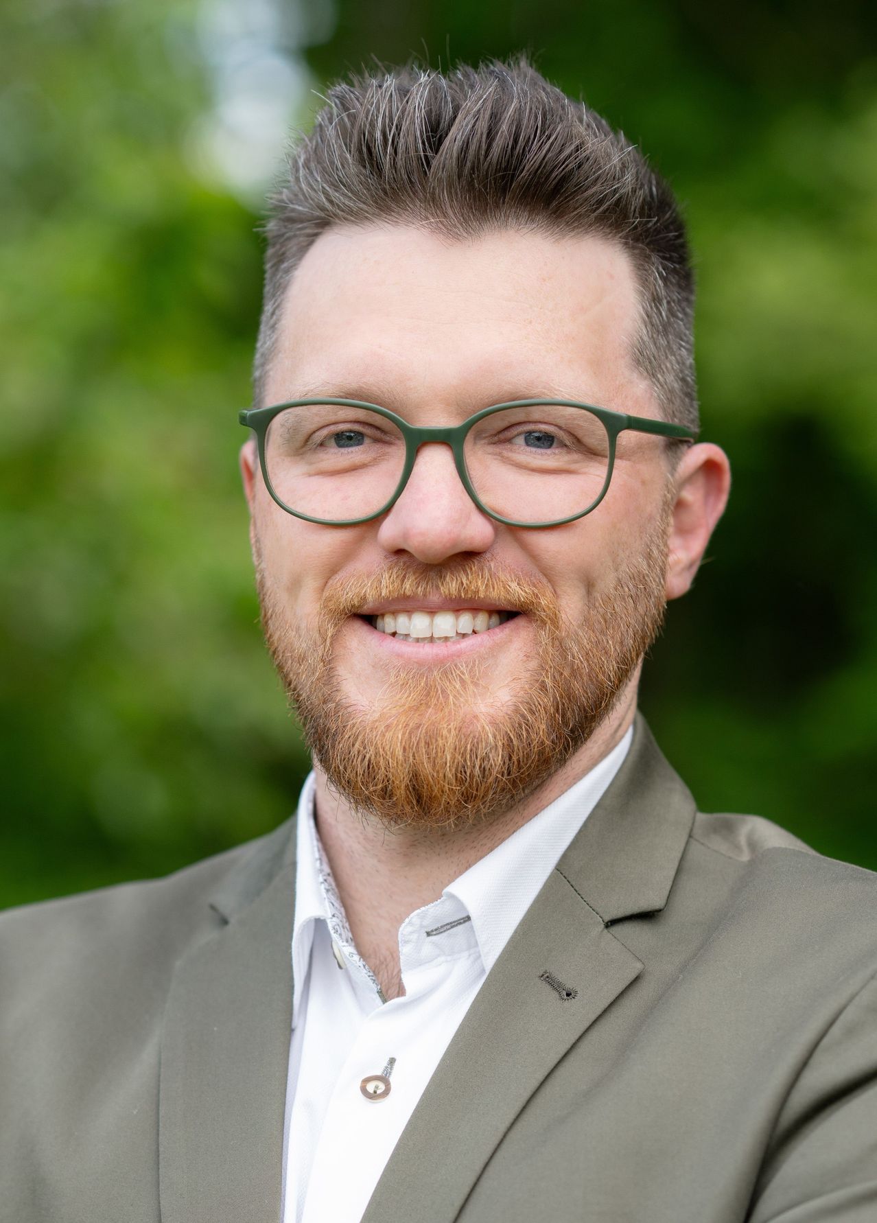 Bild enthält, Head, Person, Face, Smile, Beard, Adult, Male, Man, Suit, Glasses