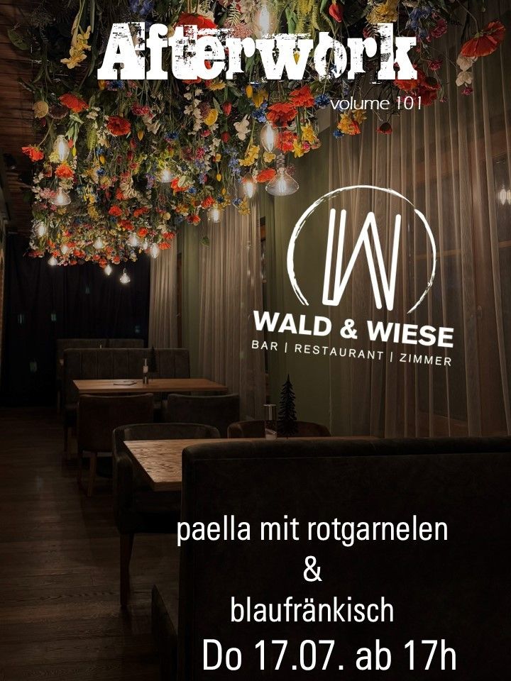 Ein Restaurantmenü zeigt eine Paella mit roten Paprika und Blauschimmelkäse. Die Einrichtung umfasst hängende Blumen und einen Baum in der Ecke. Der Name 'WALD & WIESE' ist prominent angebracht.