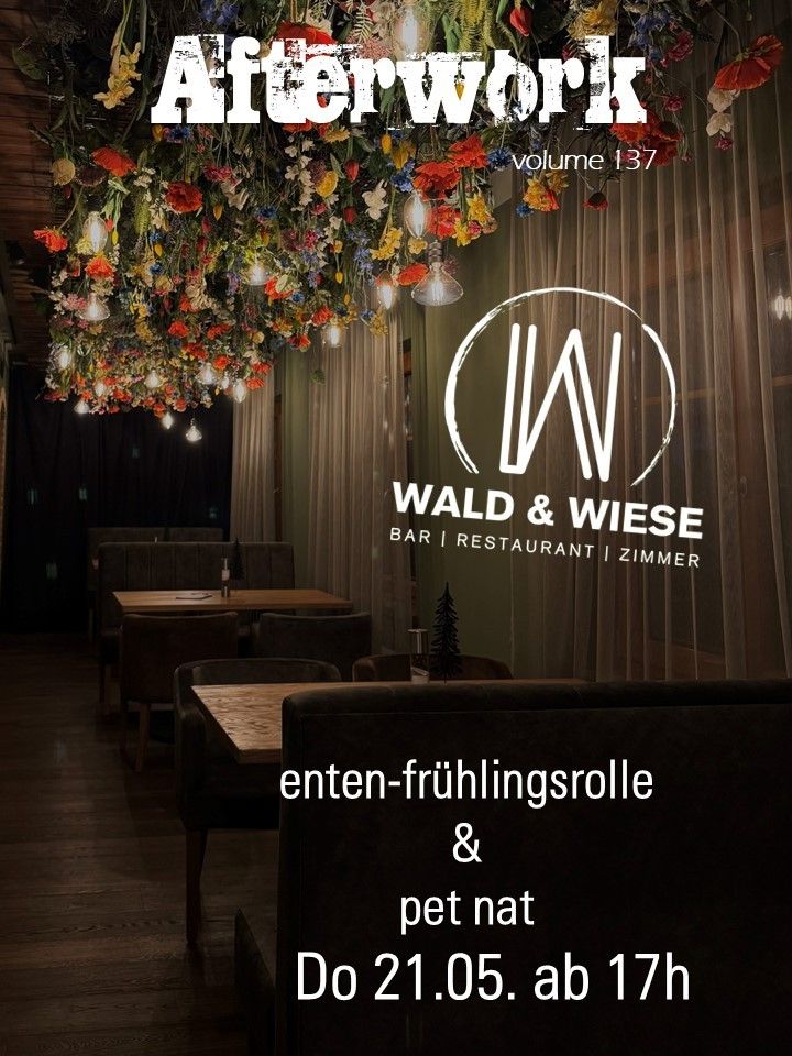 The interior of a restaurant named Wald & Wiese, featuring a floral ceiling, wooden tables, and decorative elements. The walls have white curtains and a tree decoration.