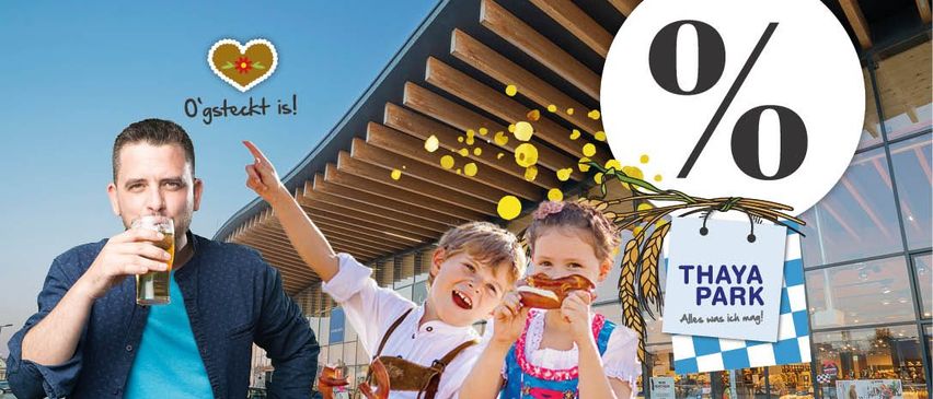 Eine Werbung zeigt einen Mann und zwei Kinder vor einem Einkaufszentrum. Der Mann zeigt auf ein Schild mit einer goldenen Münze und dem Text '0%'. Die Kinder essen Brezeln und Würstchen. Der Text lautet 'Thaya Park' und 'Alles was ich mag!'.