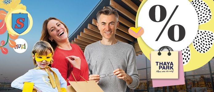 Eine Familie vor einem Geschäft mit einer 0% Aktion, ein Kind in einem Superheldenkostüm, einem Einkaufsbeutel und einer Brille. Das Geschäft hat ein modernes Design.