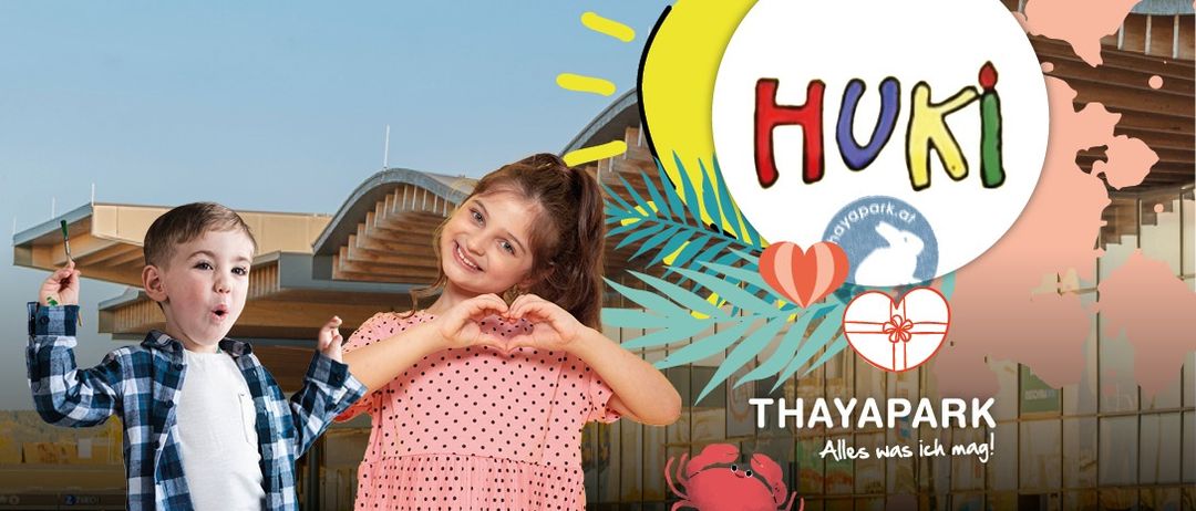 Zwei Kinder bilden mit ihren Haenden ein Herz vor einem bunten Hintergrund. Es steht HUKi und THAYAPARK. Das Maedchen traegt ein rosa gepunktetes Kleid.