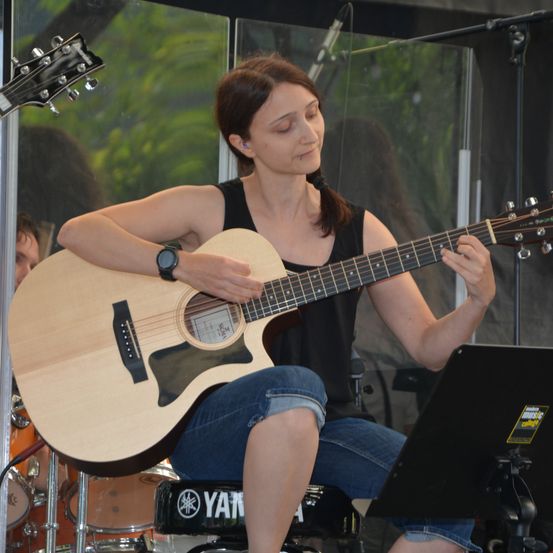 Bild enthält, Guitar, Musical Instrument, Person, Concert, Wristwatch, Adult, Female, Woman, Laptop, Face