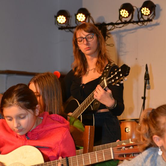 Bild enthält, Guitar, Musical Instrument, Person, Child, Female, Girl, Glasses, Microphone, Face, Necklace