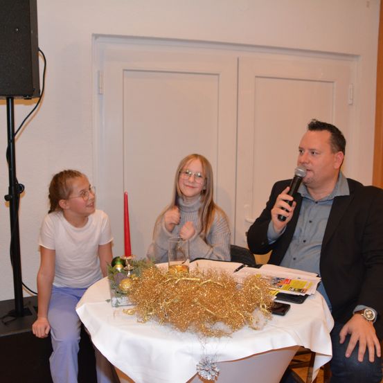 Bild enthält, Plywood, Microphone, Adult, Male, Man, Person, Female, Woman, Face, Flower Arrangement