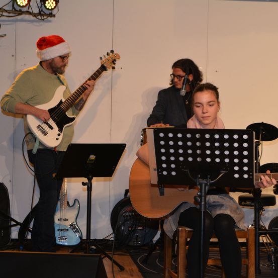 Bild enthält, Group Performance, Music Band, Musical Instrument, Person, Guitar, Adult, Male, Man, Microphone, Hat