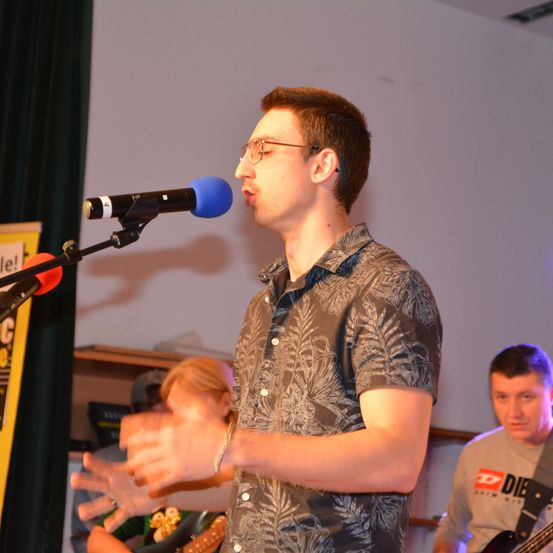 Bild enthält, Microphone, Person, Adult, Male, Man, Guitar, Finger, Crowd, Face, Child