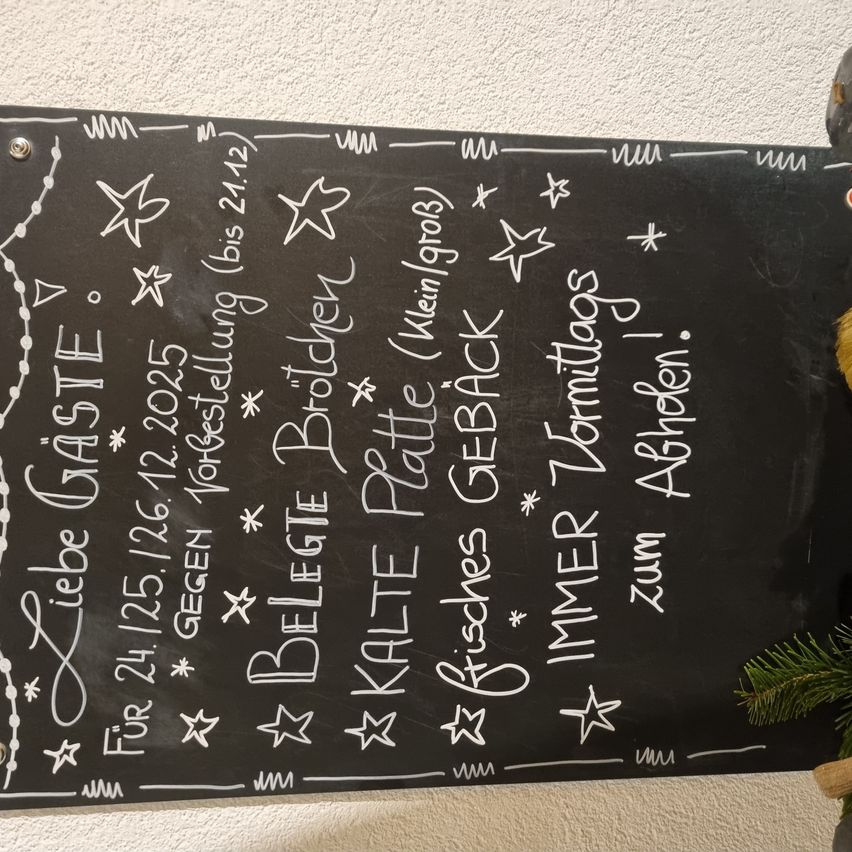 Eine Tafel listet Daten und Aktivitäten für 2023 auf, darunter 'Liebe Gäste' und 'Kalte Platte', mit verschiedenen Sternen und Dekorationen.