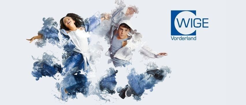 Zwei Personen springen fröhlich in der Luft, umgeben von blauen und weißen Spritzern. Das Bild zeigt das WIGE Vorderland-Logo auf der rechten Seite.