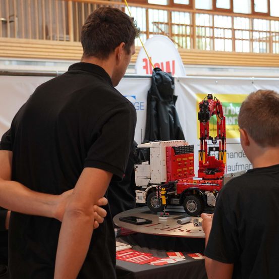 Bild enthält, Clothing, T-Shirt, Person, Electronics, Mobile Phone, Phone, People, Market, Head, Indoors