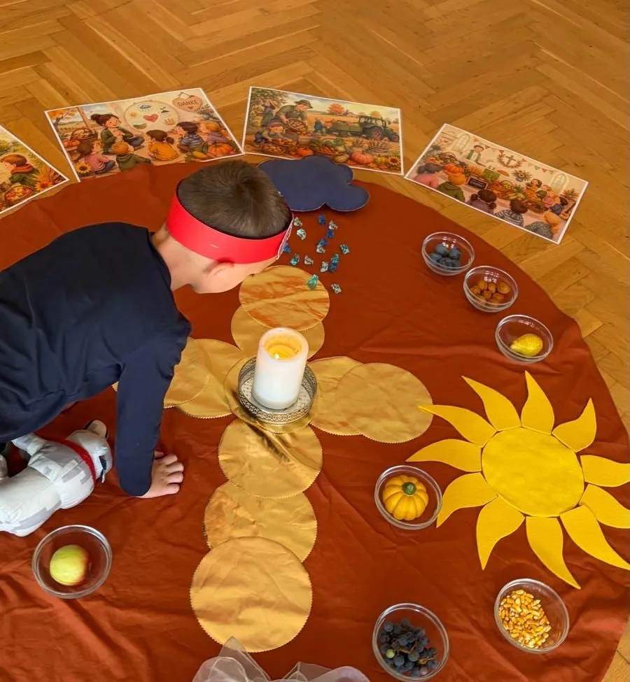 Ein Kind spielt mit einer Sonnenblumen-Aktivität auf einem Holzboden, umgeben von verschiedenen Lebensmitteln und Bildern.