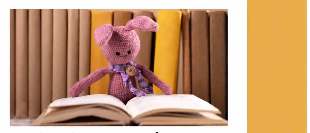 An advertisement for a children's event at the Fürstenfeld Stadtbücherei. The poster features a pink crocheted bunny sitting on an open book, with a stack of books in the background. The text is in German and invites children aged 0 to 3 years to join for a joyful hour of reading, discovery, and relaxation.