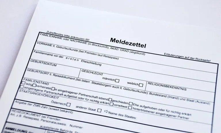 Ein Formular mit dem Titel 'Meldezettel' für die Registrierung, das Familienname, Vorname, Geburtsdatum, Geschlecht, Familienstand und weitere persönliche Angaben anfordert. Es enthält Anweisungen auf der Rückseite.