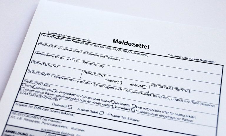 Ein Formular mit dem Titel 'Meldezettel' für die Registrierung, das Familienname, Vorname, Geburtsdatum, Geschlecht, Familienstand und weitere persönliche Angaben anfordert. Es enthält Anweisungen auf der Rückseite.