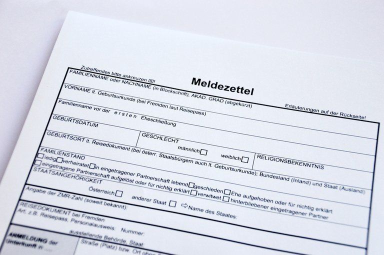 Ein Formular mit dem Titel 'Meldezettel' für die Registrierung, das Familienname, Vorname, Geburtsdatum, Geschlecht, Familienstand und weitere persönliche Angaben anfordert. Es enthält Anweisungen auf der Rückseite.
