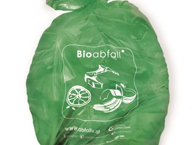 Ein grüner biologisch abbaubarer Müllsack mit der Aufschrift Bioabfall, konzipiert für organische Abfälle, mit verschiedenen Symbolen wie einem Obststück, einem Blatt und einem Recycling-Symbol darauf.